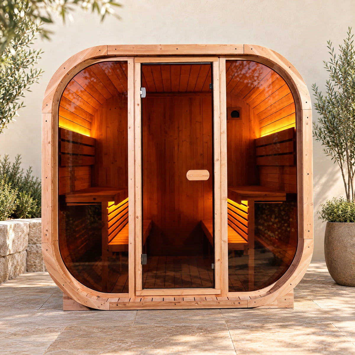 Daylight front view of the spruce sauna with broad glazing and a rounded timber surround.