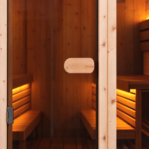 Detail of the oval timber pull on the right side of the spruce sauna’s glass door.