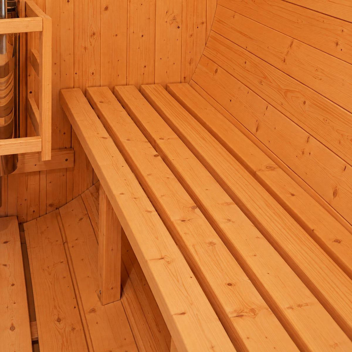 Close view of slatted timber seating against the curved interior lining of the barrel sauna.