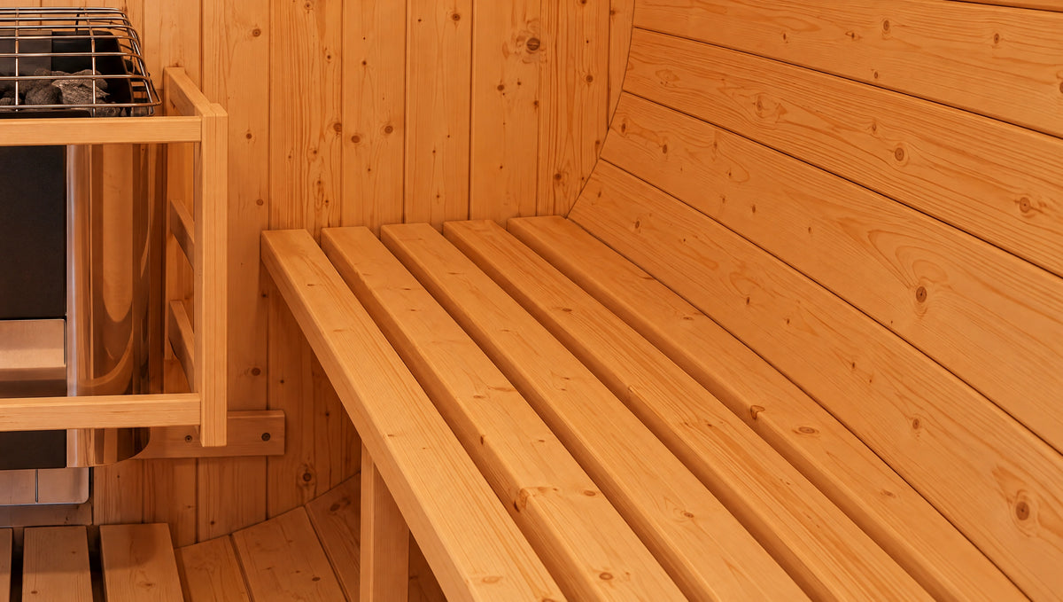 Wide detail of the barrel sauna’s timber bench slats and curved wall lining.
