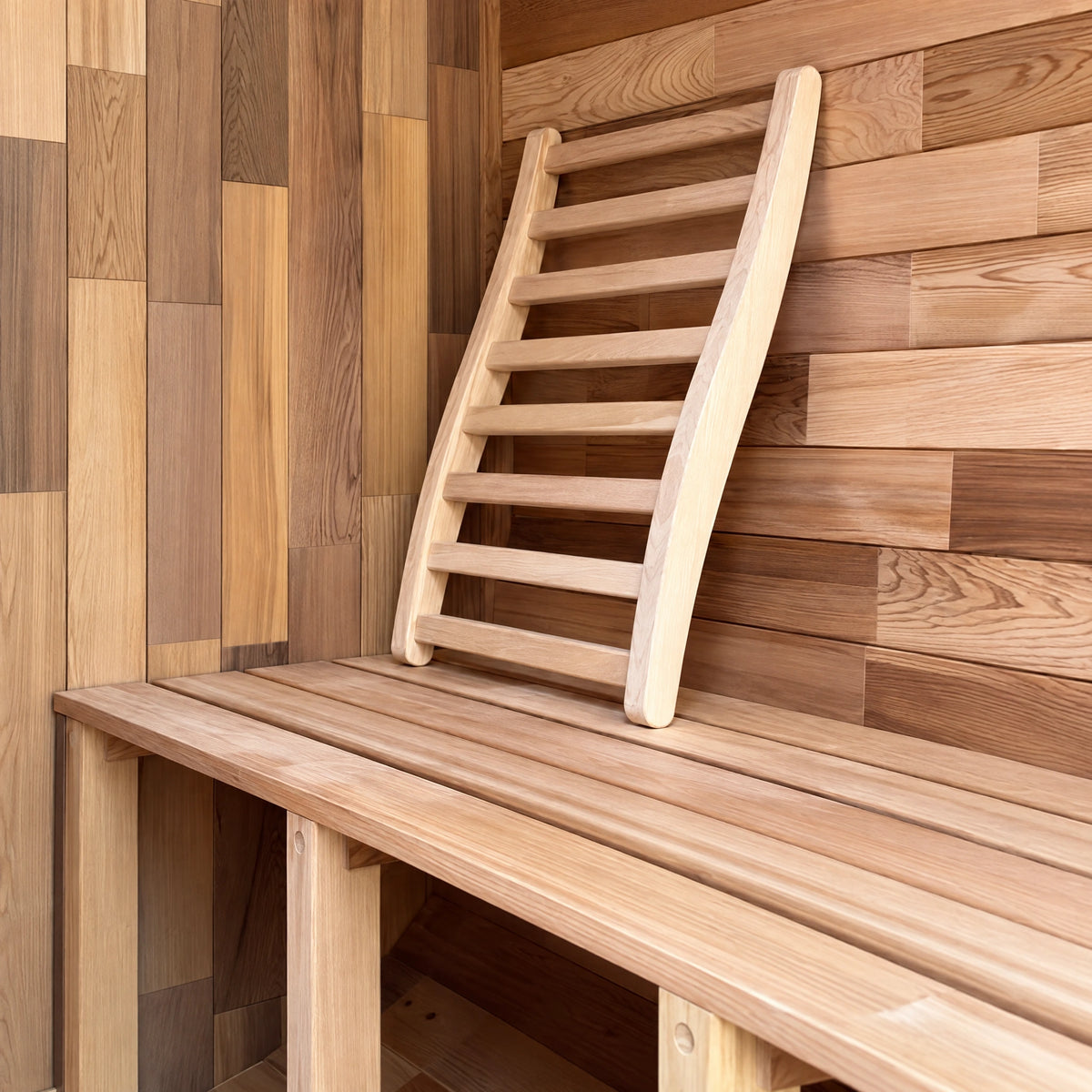 Open slatted cedar bench with a separate ladder-style backrest against timber lining.